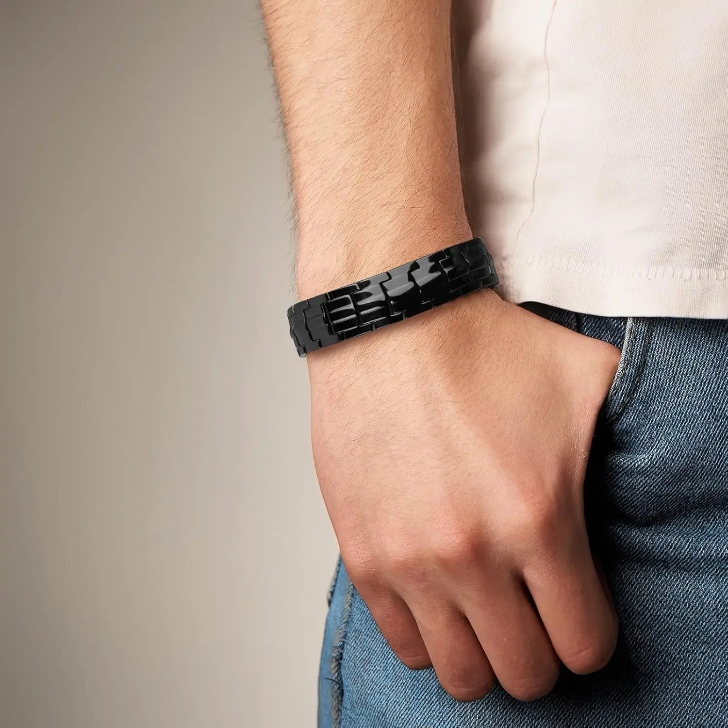 Black bracelet on a wrist with a neutral background